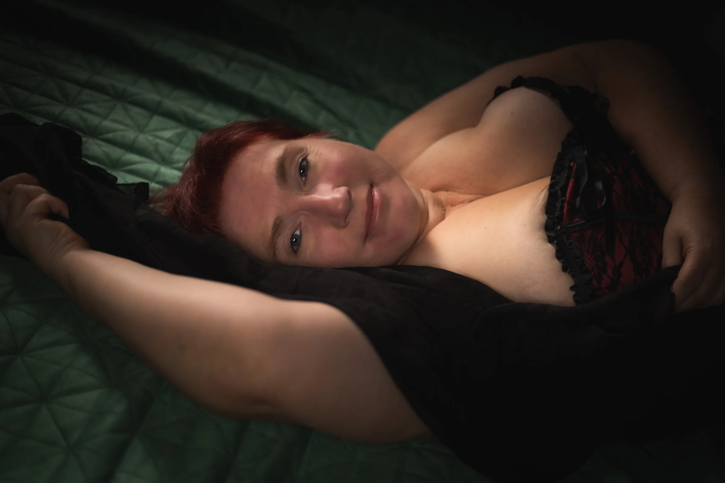 Liegende Pose auf einer grünen Decke mit ausgestrecktem Arm.